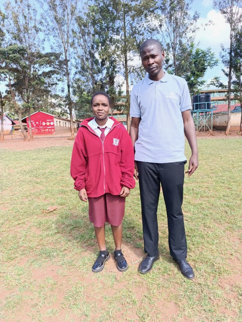 A secondary school student in her maroon school uniform with her Soma Initiative coordinator