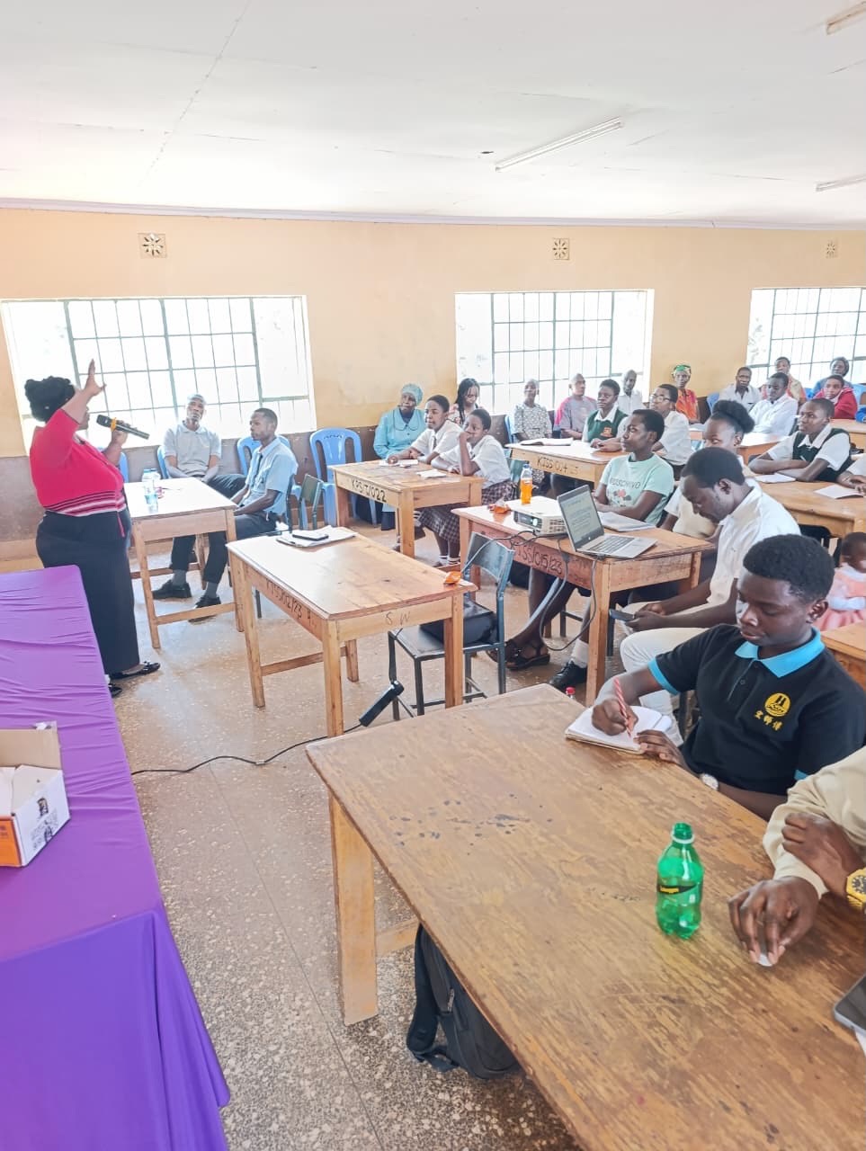 A facilitator addressing students and parents during a Soma Initiative session in a classroom