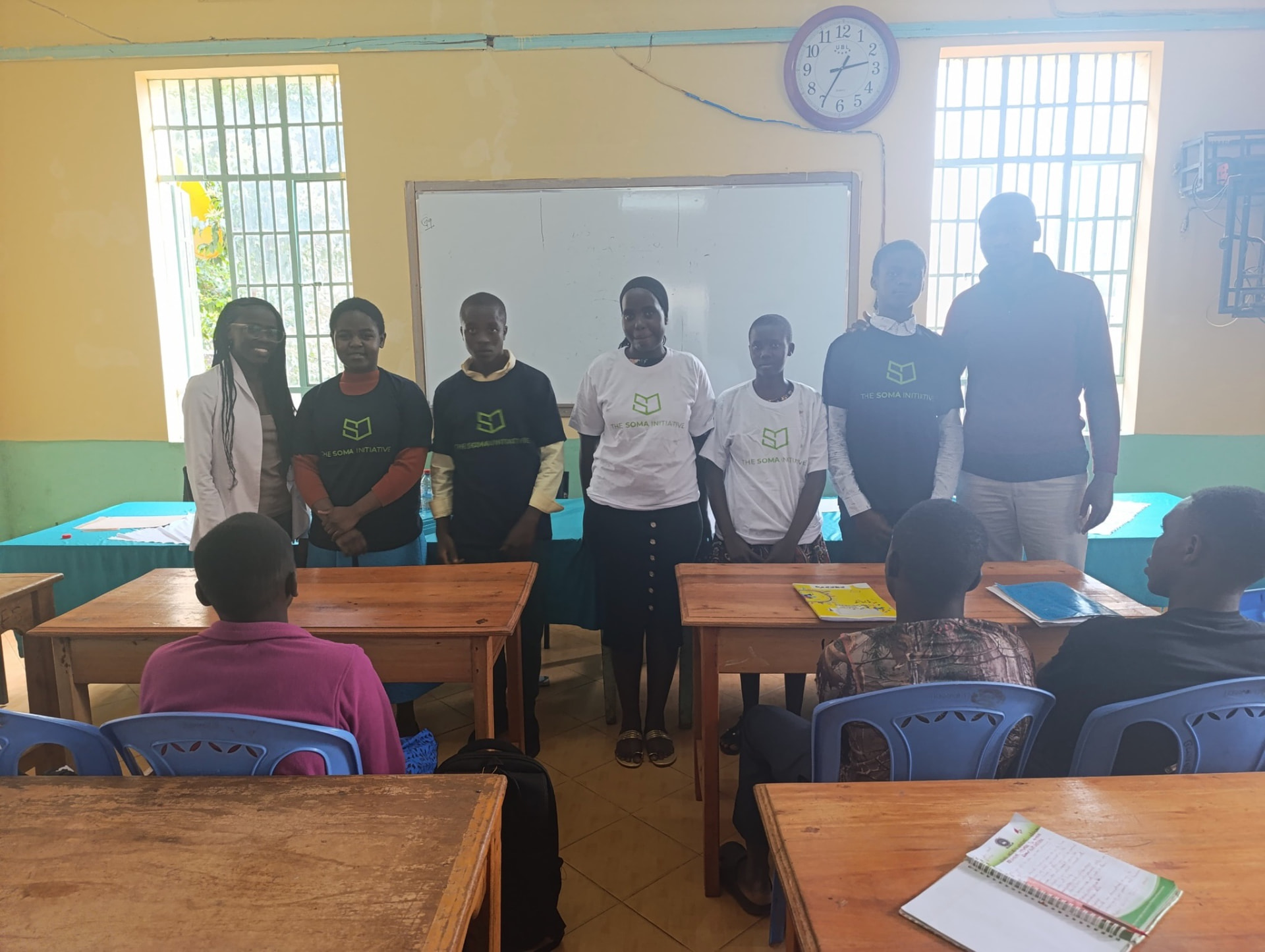 Students and volunteers wearing The Soma Initiative t-shirts at the front of a classroom